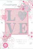 The anniversary card shown here offers a gentle, almost whisper-soft tribute to enduring love, blending pastel pinks and silvery greys to create a mood of treasured intimacy that suits a quiet evening in Chislehurst. At the centre of the design, the word LOVE is beautifully spelled out in slightly raised, glitter-dusted letters, giving a subtle embossed effect that is both visually striking and pleasing to touch. The glitter is fine and controlled, adding just enough shimmer to echo candlelight on a celebratory dinner table. These central letters are set against a blush-pink rectangular panel that provides a soft contrast to the card's lighter background, much as focal flowers stand out within an anniversary bouquet delivered from Florist Chislehurst. Curling out from around the word, delicate blooms in blush, mauve, and soft grey seem to unfurl with the softness of watercolour. Their petals and leaves are slender and flowing, suggesting both lightness and care, like stems laid out thoughtfully on a florist's bench. Tiny flourishes-sweeping swirls, miniature petals, and the faint outlines of butterflies-add a sense of movement and whimsy, evoking the grace of an English spring garden just after a light shower. The background remains a muted, velvety pink, allowing the floral pattern and lettering to stand forward without ever competing. Across the card, in graceful, understated script, appear the words On Our Anniversary and I love you today and always, their tone sincere rather than showy. Together, the elements create an impression of quiet celebration and heartfelt gratitude, making this card a tender keepsake to pair with fresh anniversary flowers hand-delivered throughout Chislehurst and the surrounding neighbourhoods.